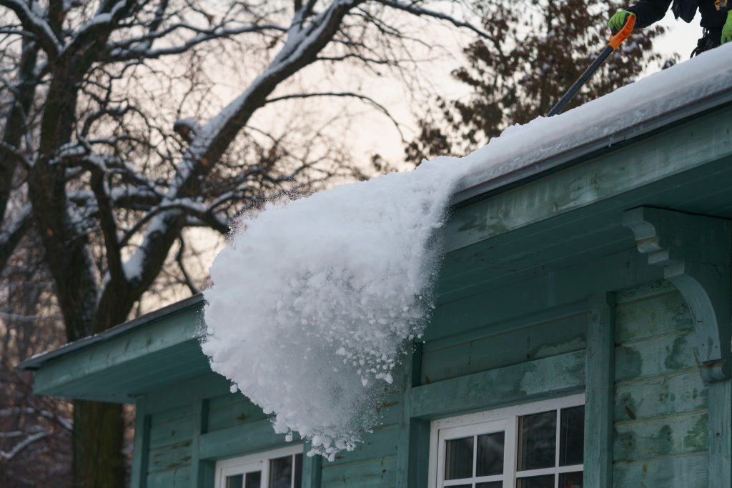 Ice dams built up on a residential roof, leading to homeowners wondering "How do you remove ice dams?"