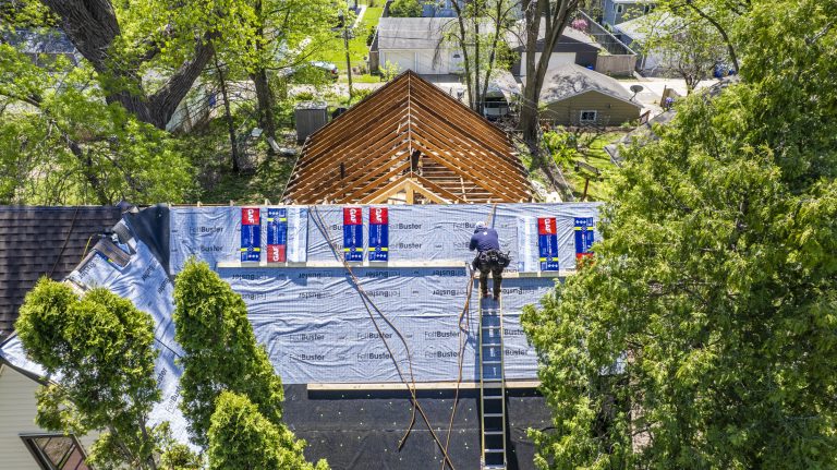 Roof decking and roof underlayment during a roof replacement, prompting the question "How long does a roof replacement take?"
